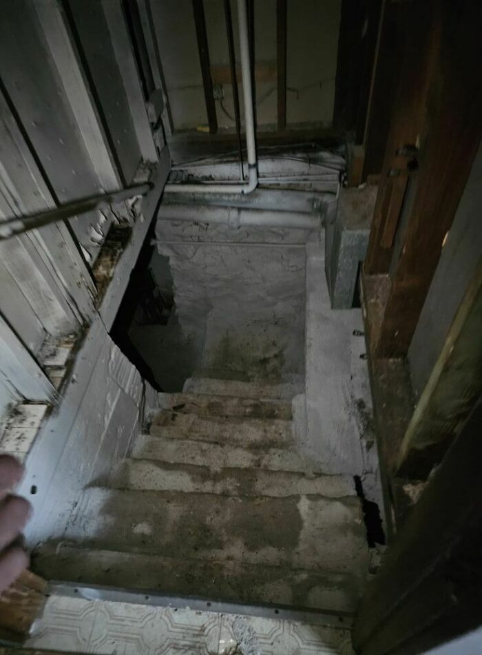 Unsafe stairs leading into a dark basement, illustrating the concept of "death stairs."