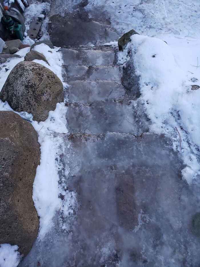Icy "death stairs" covered in snow and ice, surrounded by rocks, creating a hazardous path.