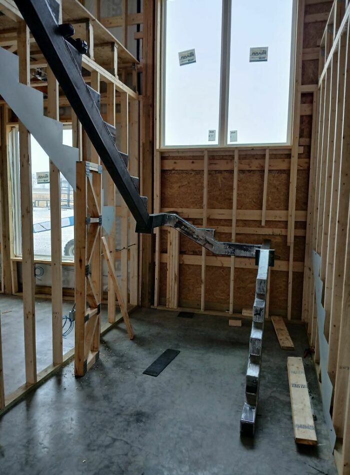 Unfinished construction with dangerous-looking stairs inside a wooden frame building.
