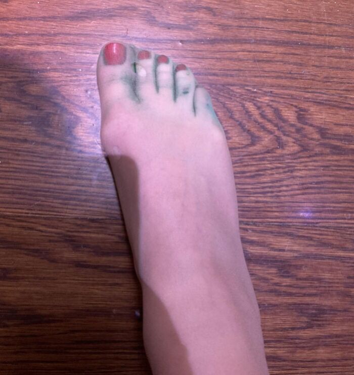 Foot with green stains on wooden floor, showcasing a budget wedding fail.
