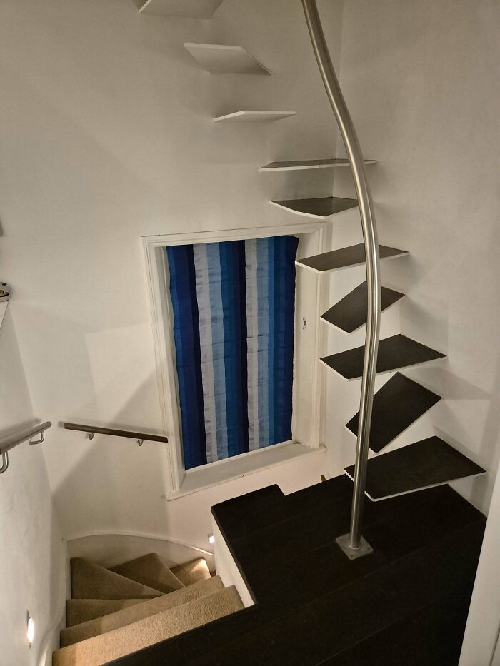 Narrow spiral staircase with irregular steps, emphasizing the concept of "death stairs" due to its precarious design.