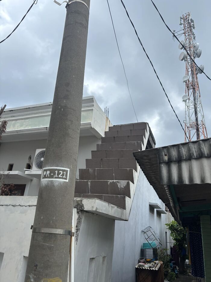Staircase abruptly ending in mid-air on a building rooftop, illustrating a hazardous design scenario.