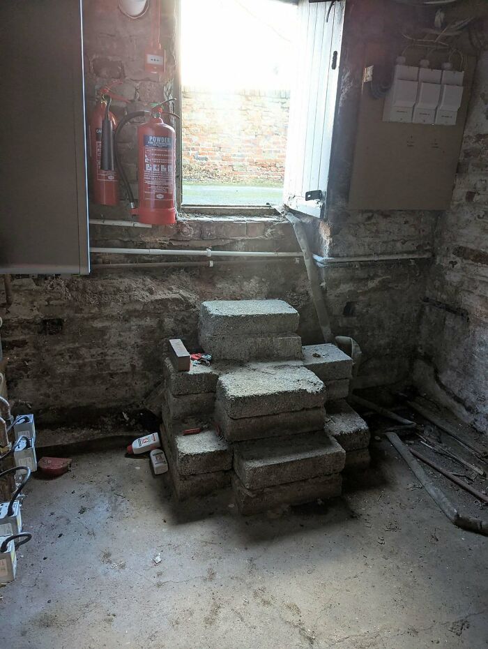 Concrete blocks form makeshift stairs in an old basement, exemplifying the concept of "death stairs" and safety risks.