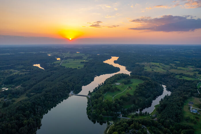 Bird’s-eye view of Lithuania at sunset, showcasing winding rivers and lush green landscapes.