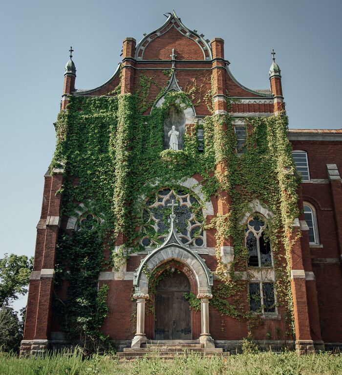 Ancient brick building with vines overtaking, showcasing nature reclaiming civilization.
