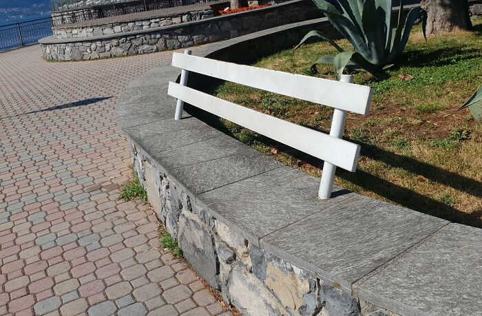 A creatively placed bench on a curved stone wall, illustrating Cities Genius Solutions in urban design.