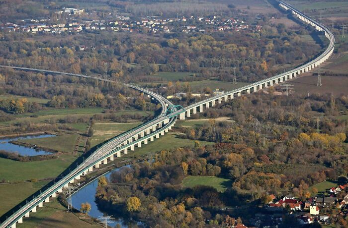 Aerial view of a long elevated highway curving through a rural landscape showcasing brilliant infrastructure design.
