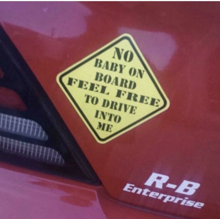 Car with a humorous "No Baby on Board" sticker, reflecting existential meme humor.