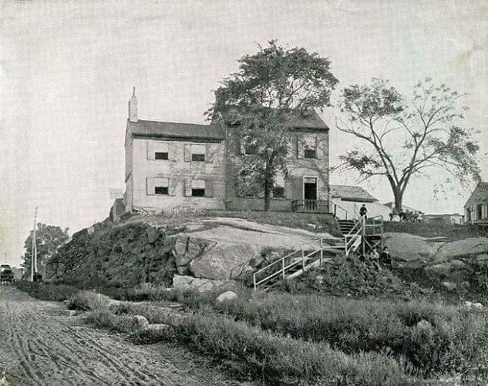 Historic house on a rocky hill with surrounding trees and vintage scenery showcasing something interesting.
