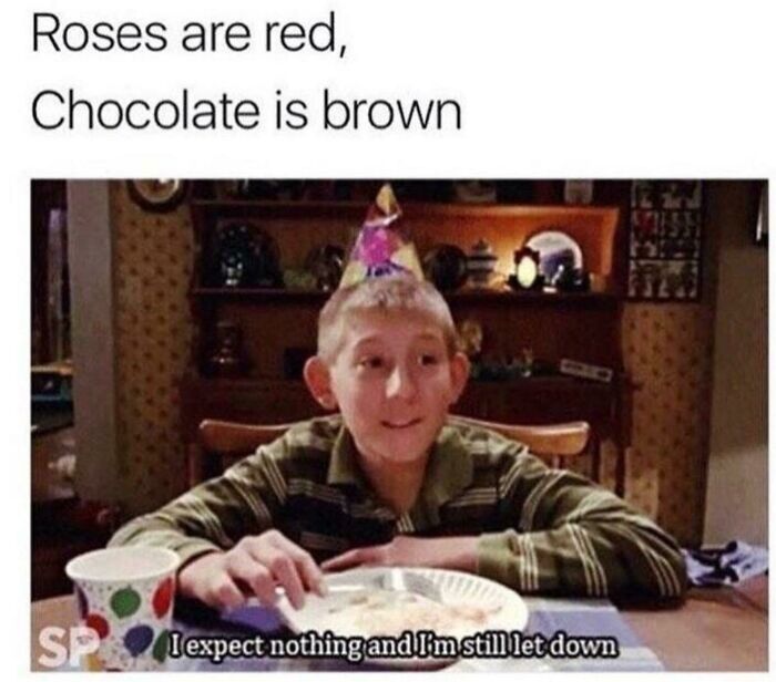 A boy wearing a party hat sits at a table with a caption expressing existential humor.