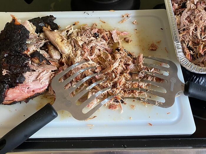 Shredded pork on a cutting board with shredding claws; a practical Amazon find.