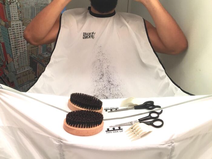 Beard grooming cape with brushes and scissors on a table, showcasing genius Amazon finds.