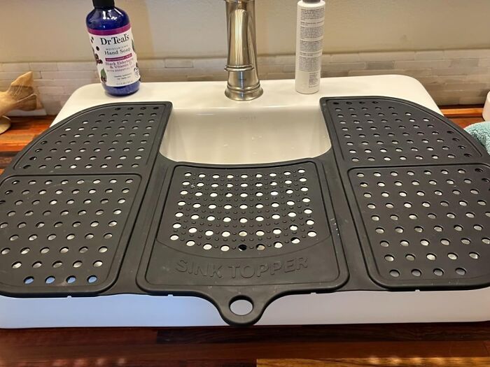 A black sink topper with holes covering a white sink, an example of genius Amazon finds.
