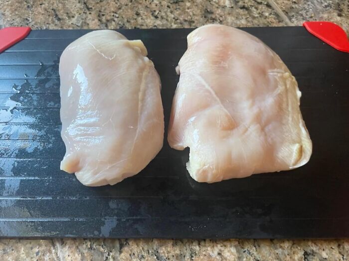 Chicken breasts on a black cutting board, possibly related to genius Amazon kitchen finds.