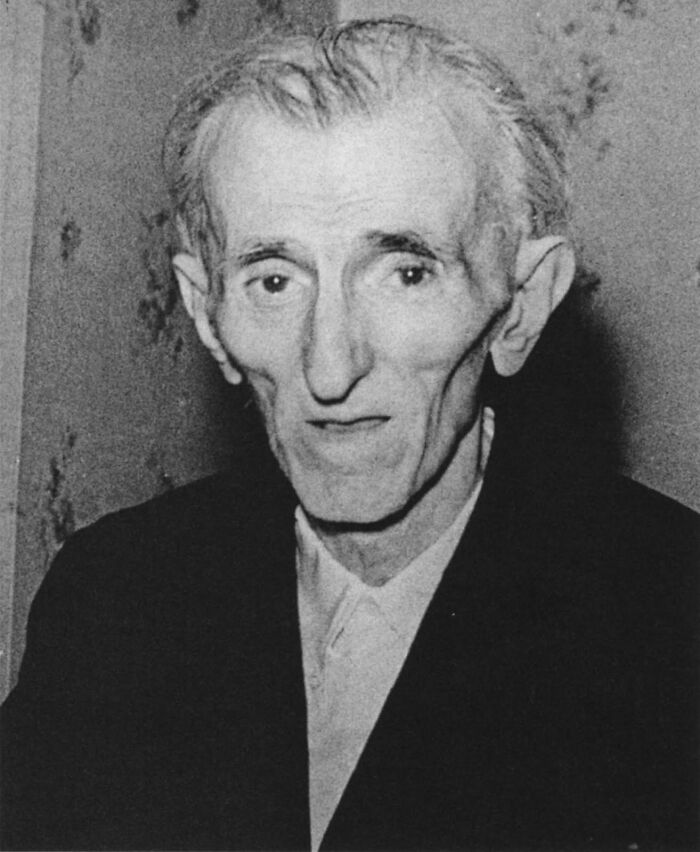 Black and white portrait of an elderly man with sharp facial features, illustrating strange Earth phenomena.