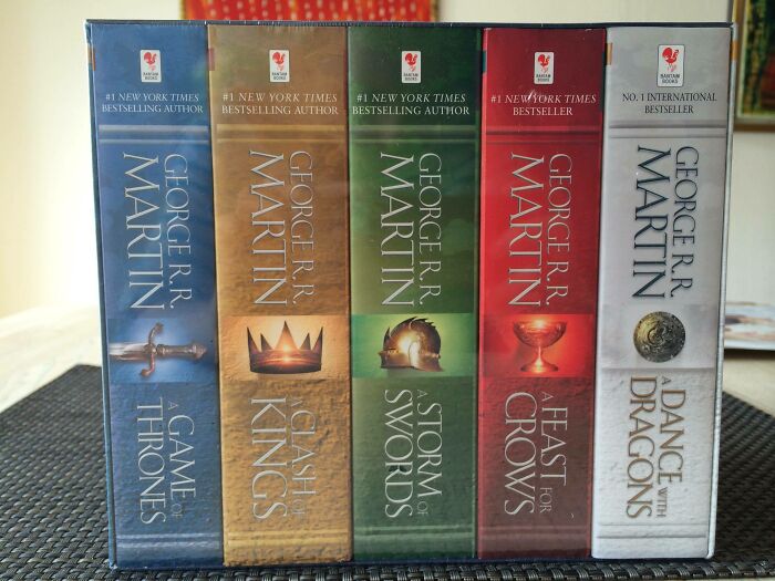 Boxed set of books by George R.R. Martin, showcasing various colorful covers.