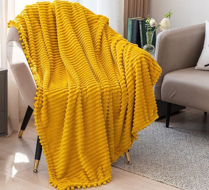 Yellow textured blanket draped over a chair, creating a cozy and joyful atmosphere.