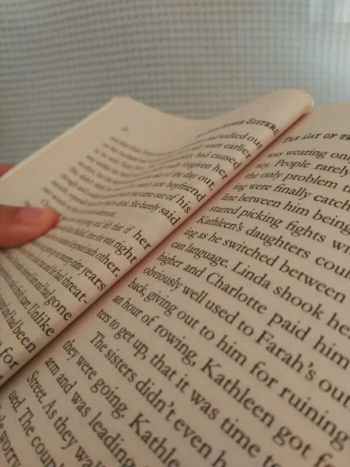 Pages of a poorly-written book with uneven text and creases, emphasizing design flaws.