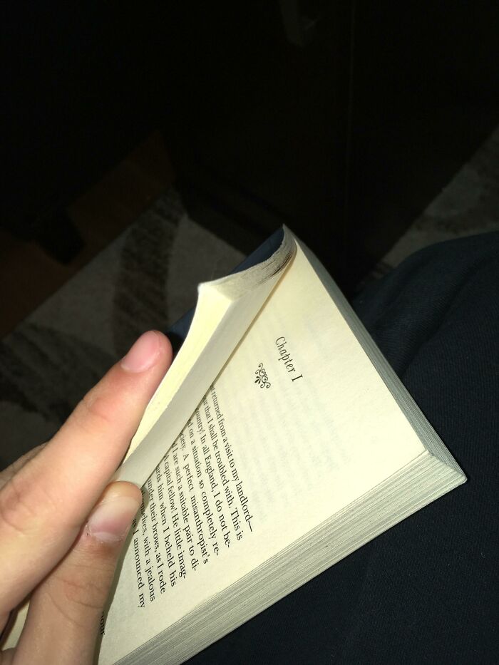 Person holding a book with upside-down text, illustrating poorly designed books.