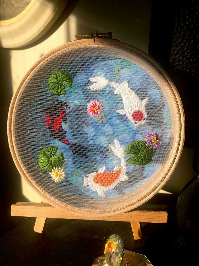 Embroidery hoop art featuring koi fish and lily pads beautifully showcasing incredible embroidery skills.