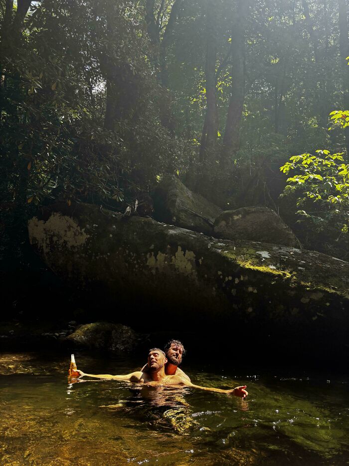 Men relaxing in a forest stream, enjoying the sunlight; an accidental Renaissance-style scene.