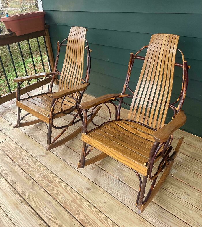 Pair of rustic wooden rocking chairs on a porch floor, showcasing unique thrift store finds with natural branch-style frames.