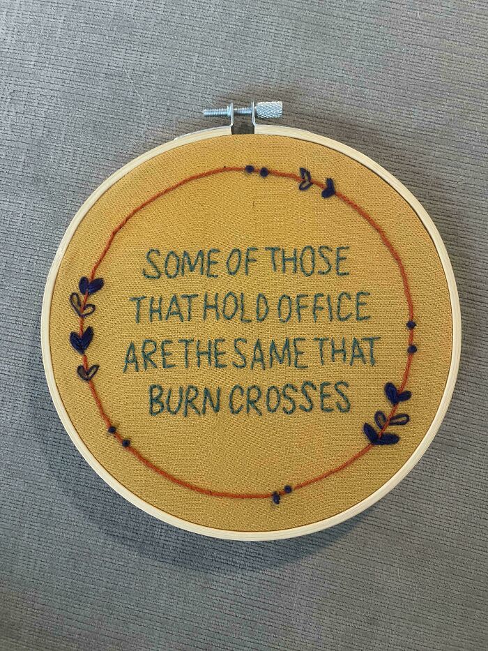 Embroidery hoop displaying a stitched quote surrounded by decorative leaves, showcasing beautiful embroidery skills.