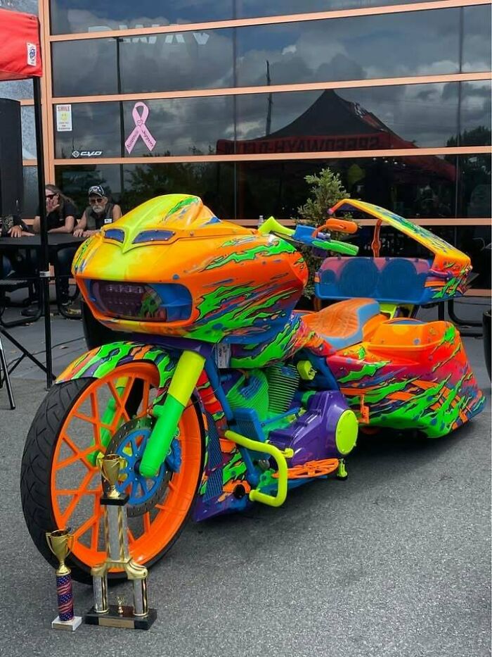 Vibrantly painted custom motorcycle with bright neon colors and patterns, showcasing examples of awful taste but great e*******n.