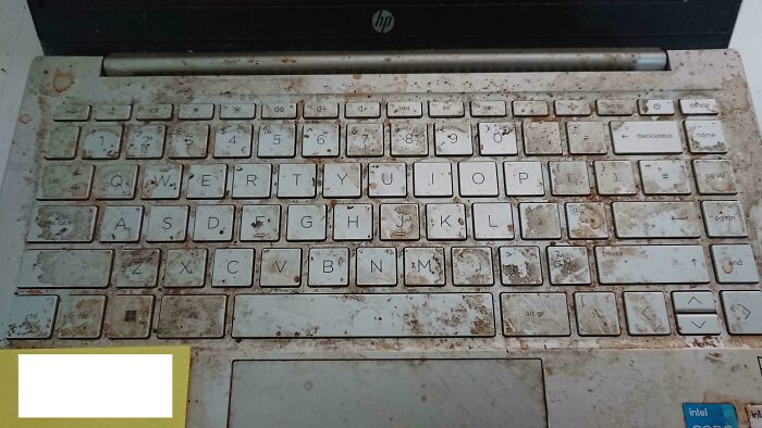 Dirty and stained laptop keyboard showing neglect and wear, illustrating tech support workers’ challenges and regrets.