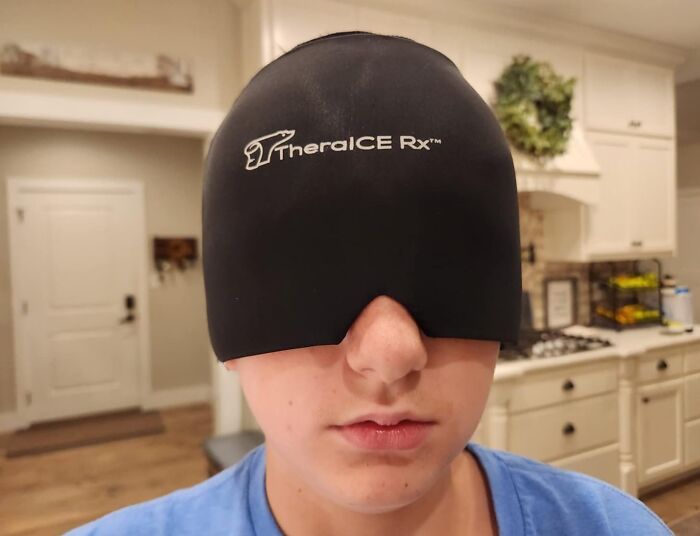 A person wearing a TheraICE Rx headwrap in a kitchen, demonstrating a clever invention.