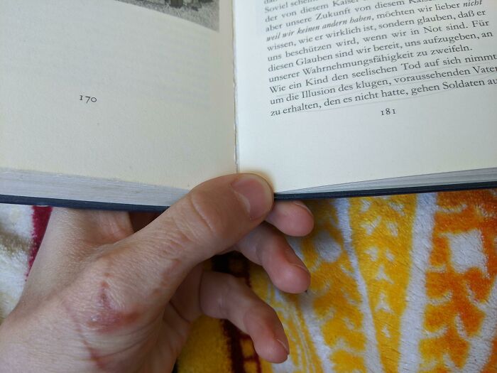 Hand holding a book with pages numbered 170 and 181, showing examples of poorly-written-designed-books.