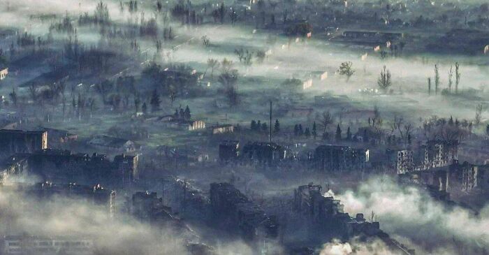 Foggy urban landscape with decrepit buildings, resembling scenes of urban hell.