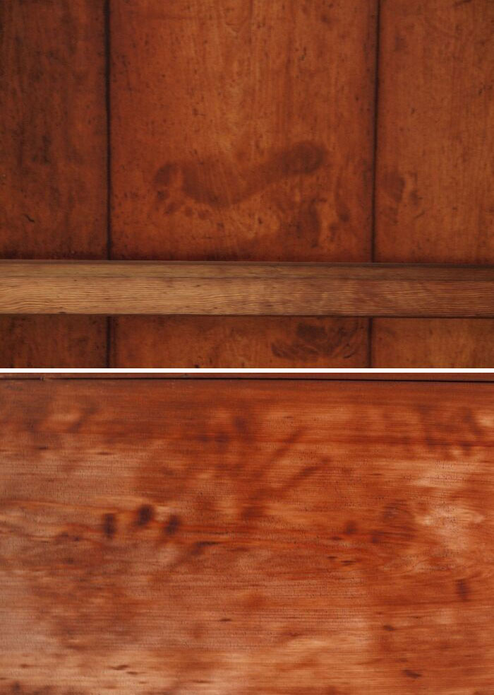 Ancient artefact with preserved handprints on aged wooden surface.