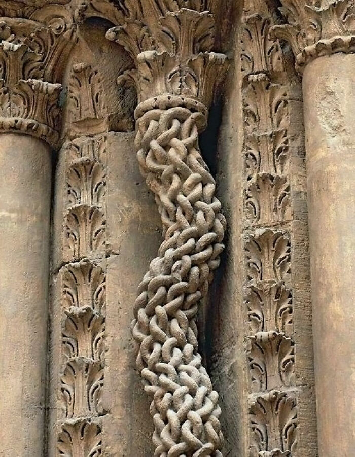 Intricate carved column detail from an ancient artefact, showcasing elaborate looping patterns and designs.