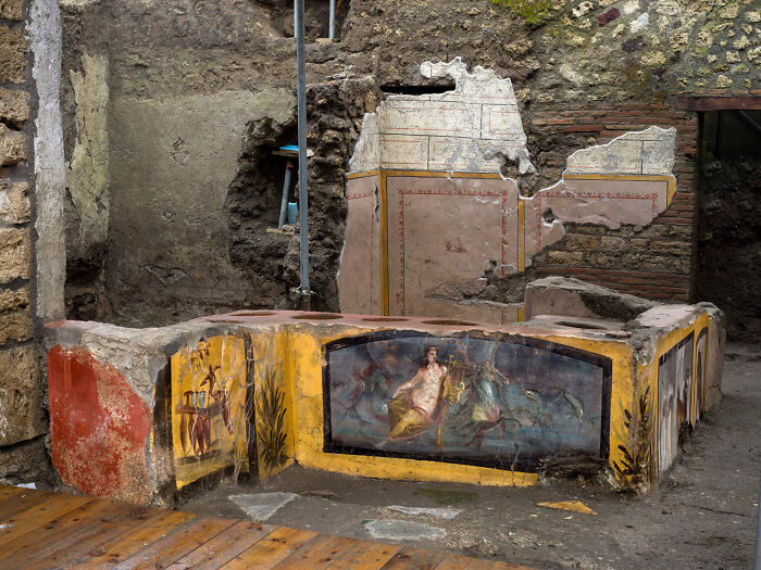 Ancient artefacts depicting murals on weathered stone walls showcasing vibrant historical art.