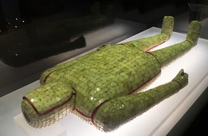 Ancient artefact: a jade burial suit displayed in a museum exhibit, showcasing intricate craftsmanship.