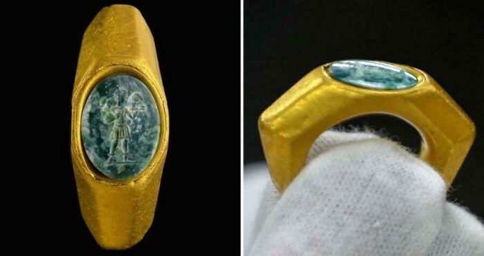 Ancient artefact: a golden ring with an engraved stone, delicately held and displayed on a black background.