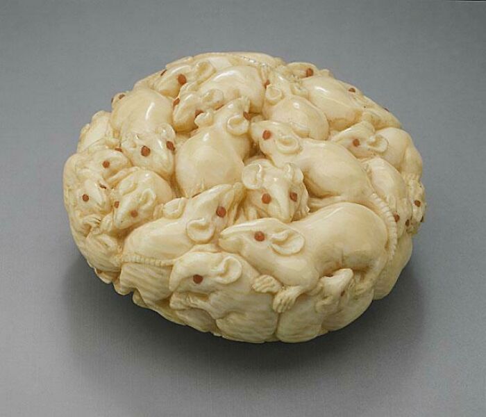 Ancient artefacts: intricately carved ivory sculpture of mice, showcasing exquisite detail and craftsmanship.