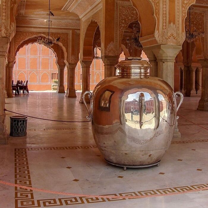 Ancient artefact: large silver urn in ornate palace interior, reflecting the surroundings.