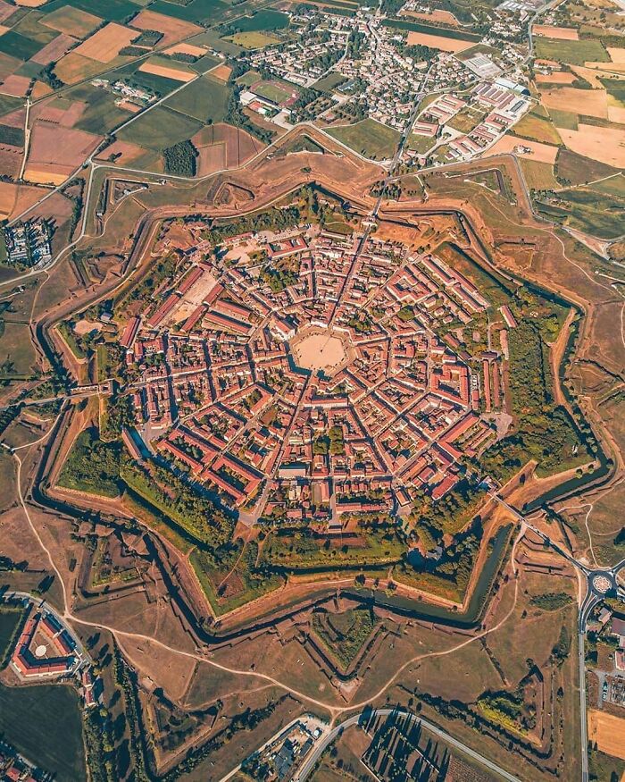 Aerial view of a star-shaped fort, one of the ancient artefacts that survived to this day, surrounded by fields and roads.