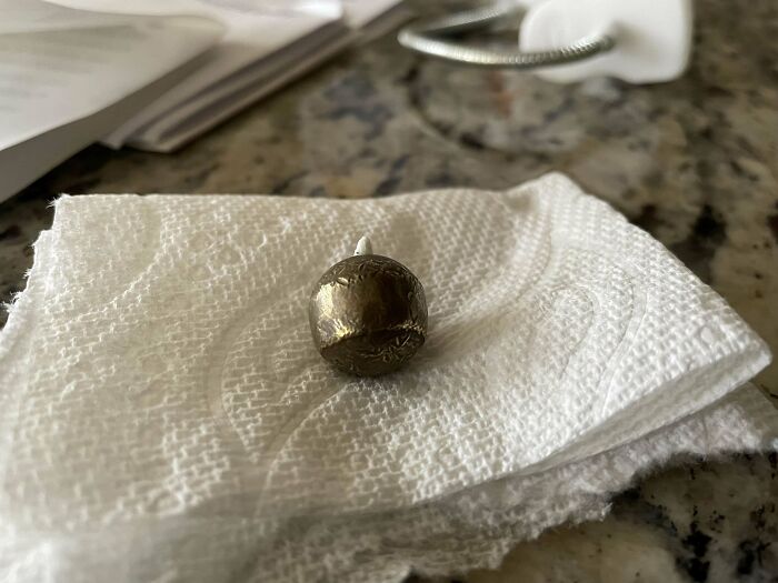 Weird object found on paper towel, resembling a small metal sphere with intricate details.