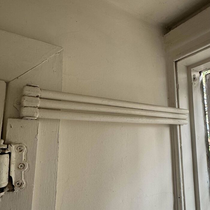 Unusual wall-mounted white triple bars, a weird object discovered in a home corner.