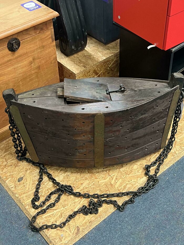 Unusual wooden object with chains found in a room, showcasing weird objects and mysterious finds.