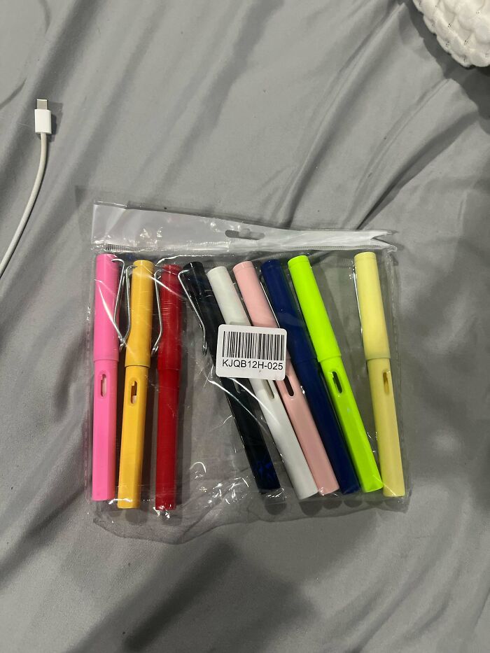 Plastic pouch with colorful pens arranged in a row, showcasing different colors: pink, yellow, red, black, and more.