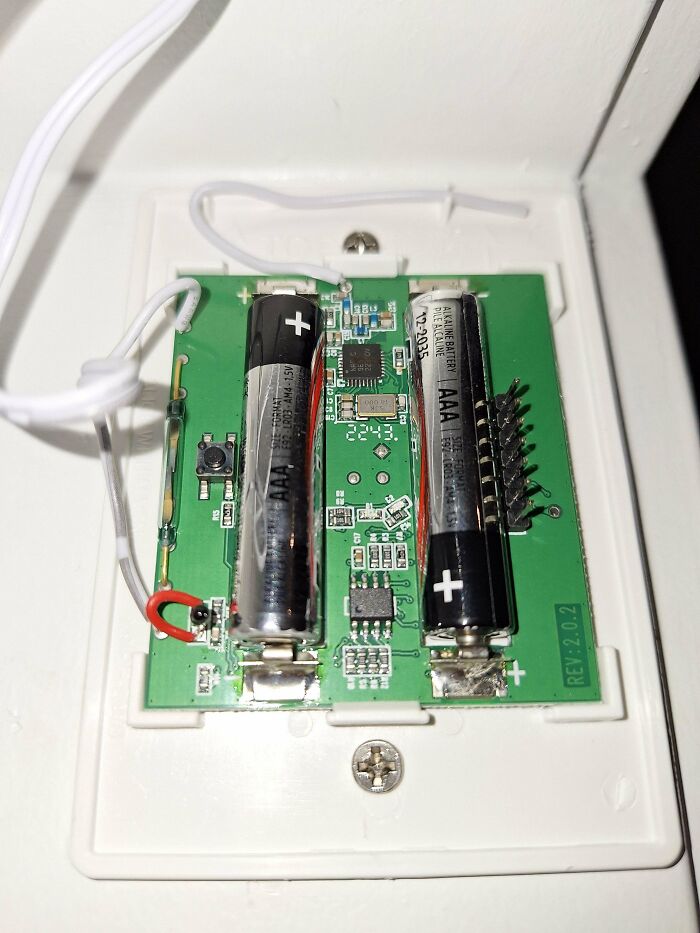 Circuit board with two AAA batteries mounted, featuring various electronic components.