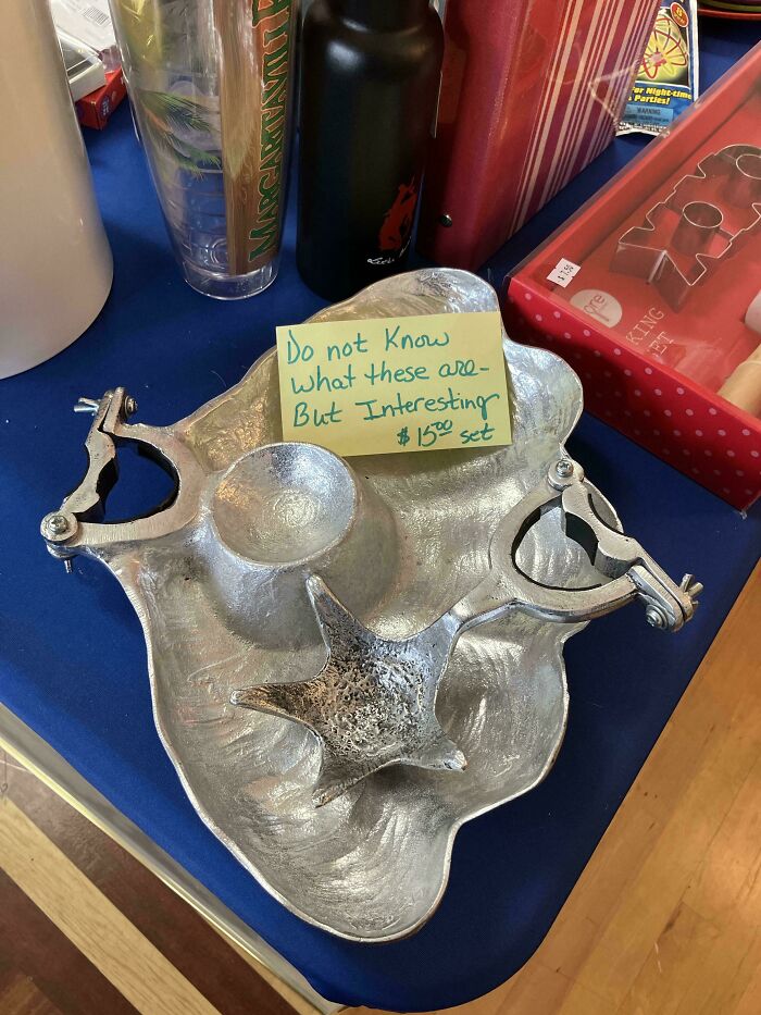 Weird object with clamps and a textured surface, displayed with a note, priced at $15, on a table with other items.