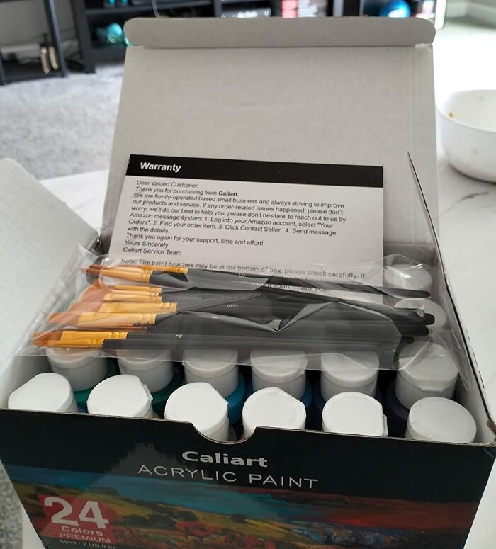 Box of Caliart acrylic paints and brushes, a possible best gift from Reddit, shown with warranty card.