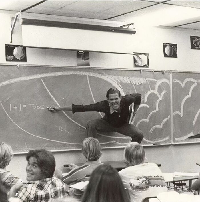 Teacher demonstrating on chalkboard, creating a moment capturing true happiness in the classroom.