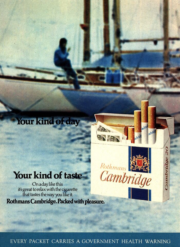 Vintage-commercials ad featuring Rothmans Cambridge cigarettes with a sailing backdrop.