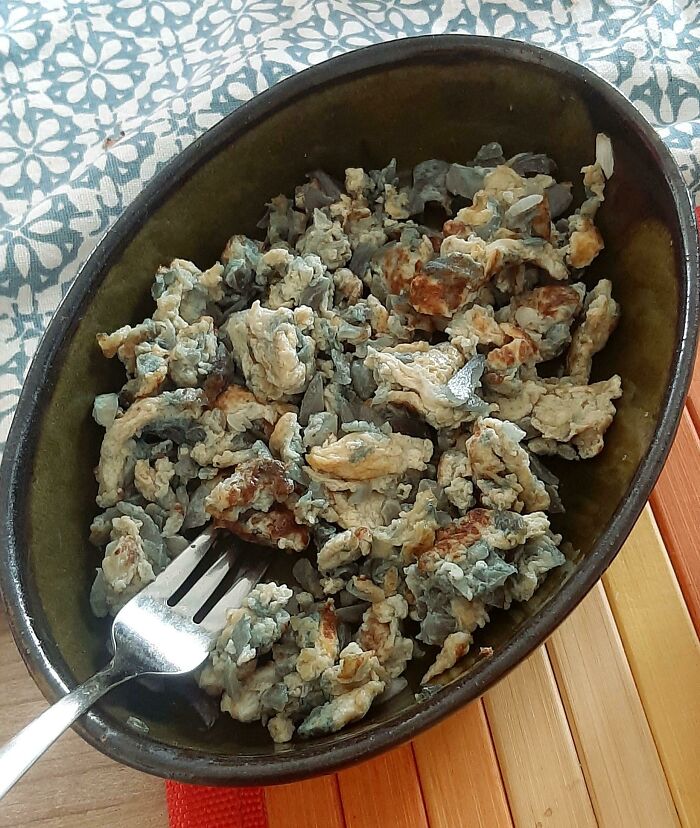 A dish of poorly cooked scrambled eggs, possibly linked to annoying boyfriends or husbands, with a fork in a bowl.